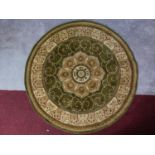 A circular Eastern rug with central pendant medallion on a green and ivory field 150x150cm