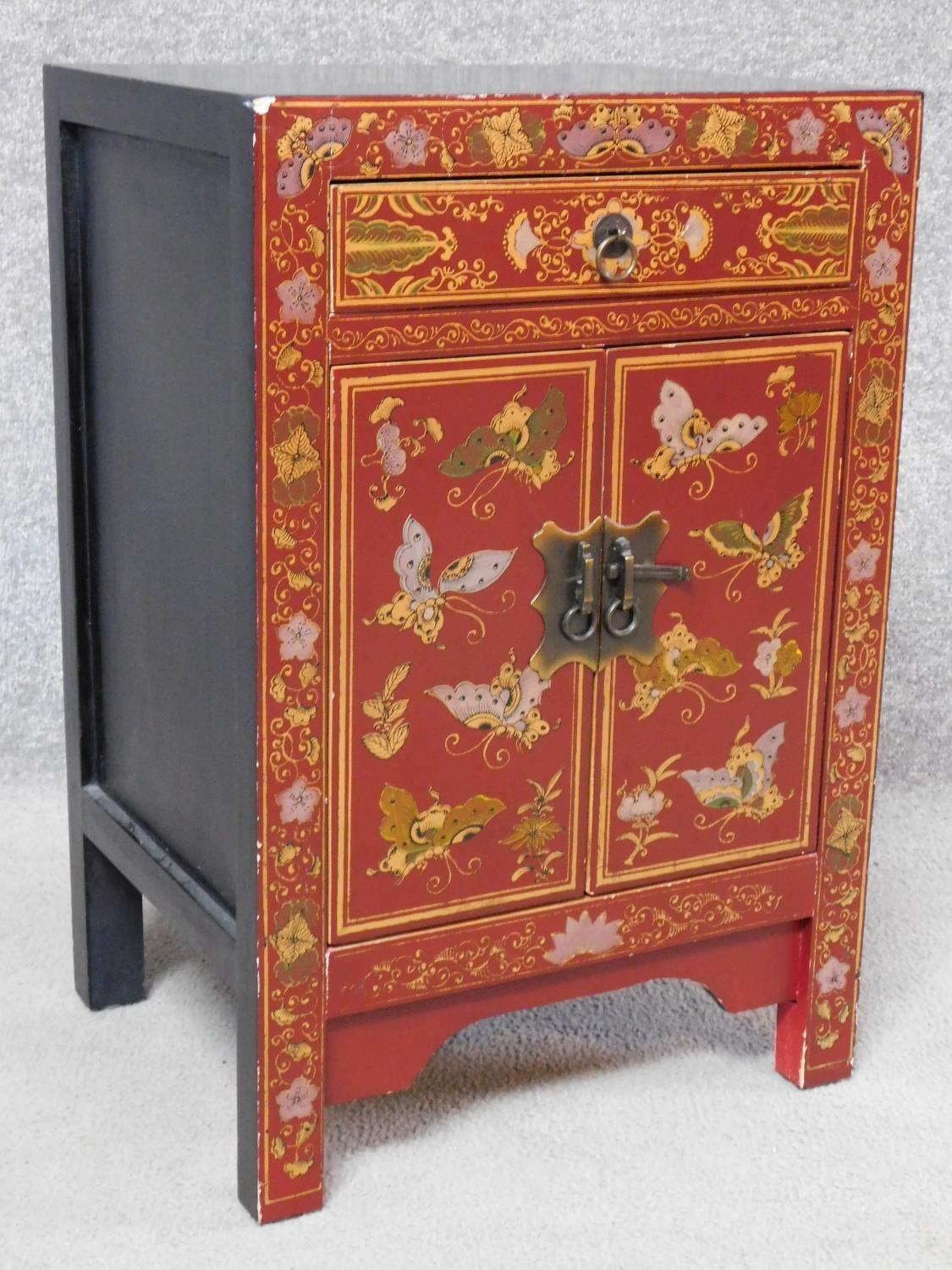 A Chinese red lacquered side cabinet with allover butterfly decoration. H.60 W.40 D.32cm