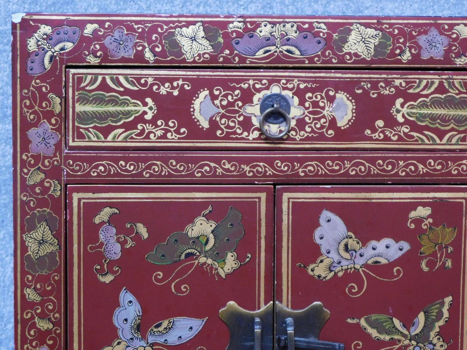 A Chinese red lacquered side cabinet with allover butterfly decoration. H.60 W.40 D.32cm - Image 5 of 6