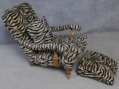 A beech framed 19th century easy armchair in faux zebra skin upholstery with matching pull out