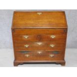 A Georgian oak bureau with fall front revealing a fitted interior with slide revealing hidden well