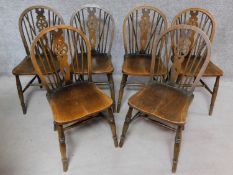 A set of six elm seated Windsor wheelback dining chairs on turned stretchered supports. H.88cm