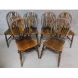 A set of six elm seated Windsor wheelback dining chairs on turned stretchered supports. H.88cm