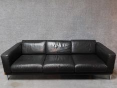 A three seater Robin Day Forum sofa in dark tan leather upholstery. H.65 W.210 D.85cm
