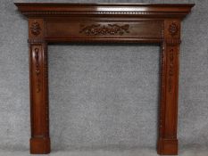 An Adam style mahogany fire surround with ribbon and swag carved central frieze. H.134 W.152cm