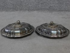 A pair of antique silver plated lidded warming dishes. With floral form and foliate sculpted