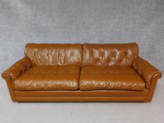 A vintage brown leather button backed sofa. H.72 W.220 D.90cm