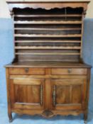 A 19th century French provincial chestnut dresser with open plate rack above two frieze drawers