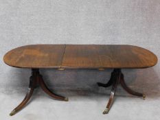 A 19th century mahogany D-end dining table with extra leaf on twin tripod bases with reeded swept