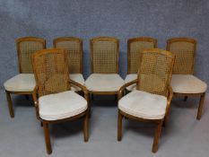 A set of seven American walnut caned back dining chairs. Including two armchairs, makers label to
