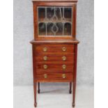 An Edwardian mahogany vitrine with Art Nouveau style leaded panel doors above 4 drawers on square