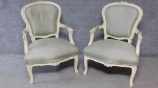 A pair of Louis XV style white painted carved frame armchairs on cabriole legs. H.97cm