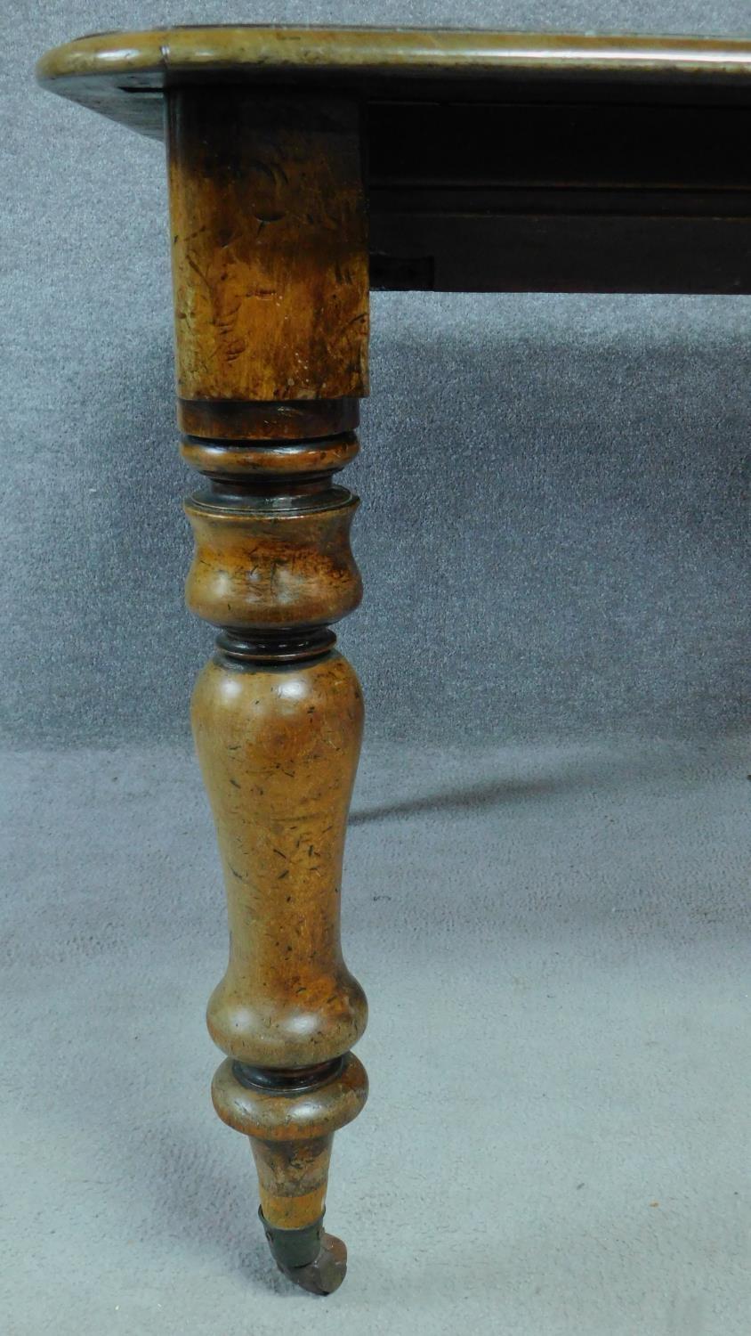A Victorian mahogany extending table on turned tapering supports terminating on brass cup casters. - Image 3 of 6