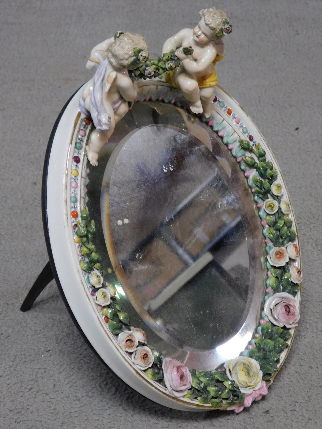 A 19th century Sitzendorf style oval shaped porcelain dressing mirror with relief flower and