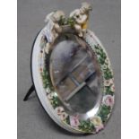 A 19th century Sitzendorf style oval shaped porcelain dressing mirror with relief flower and