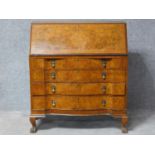 An early Georgian style burr walnut bureau with fitted interior above four graduating long drawers