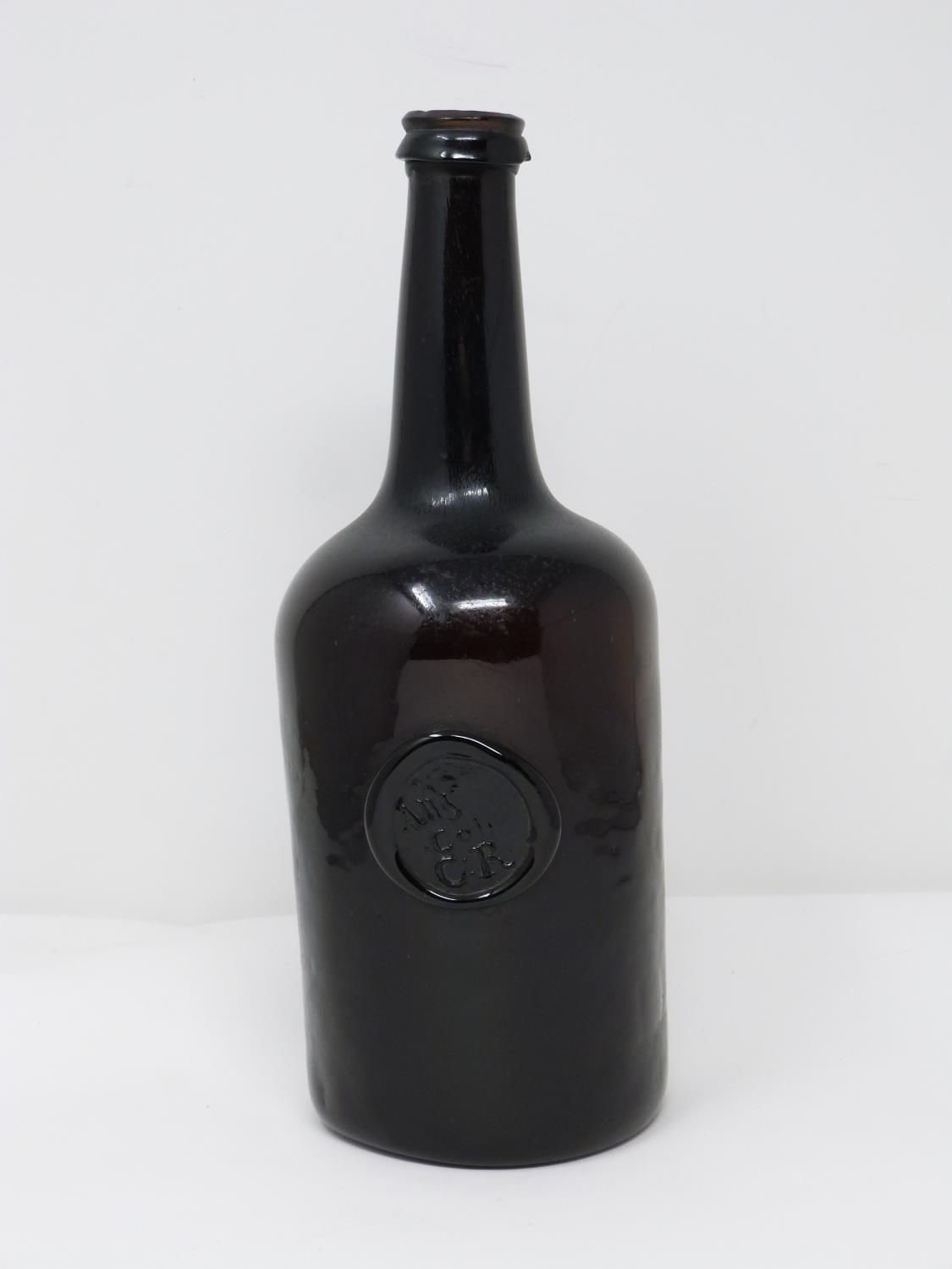 An 18th century All Souls College common room, Oxford sealed brown glass wine bottle. H25.5cm.