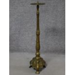 An antique floor standing brass pricket candlestick. H.77cm