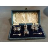 A Walker and Hall cased sterling silver cruet set. The mustard and salt pots have blue glass liners.