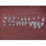 A collection of vintage glasses including a set of six brandy glasses, four engraved shot glasses, a