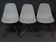 A pair of Eames Vitra dining chairs and a similar chair. H.82cm