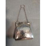 An Edwardian sterling silver ladies coin purse suspended from chain. It has scrolling engraved