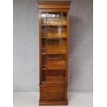 A Georgian style mahogany narrow library bookcase with glazed upper section above base drawer on