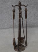 An antique cast iron fire set on stand. H.79cm