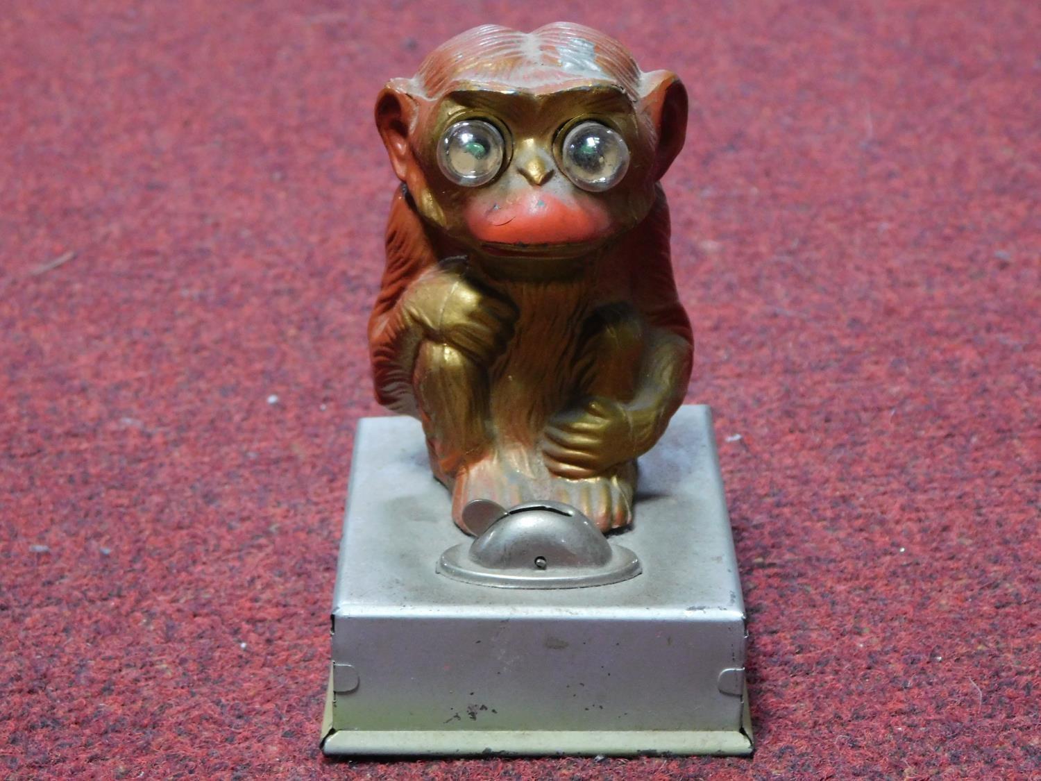 A vintage painted tin plate monkey light, it's eyes light up and is battery powered. H.12cm