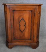 A Continental fruitwood corner cupboard with carved panel door on bracket feet. H.90x70x50cm