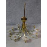 A large nine branch brass chandelier with frosted glass shades. H.110 W.110cm (two shades missing).