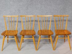 A set of four vintage Ercol style elm seated dining chairs with beech stick backs, rails and legs.