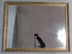 A gilt wall mirror with scrolling floral decorated frame. 112x87cm