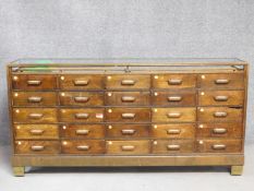 A vintage oak and brass twenty five drawer haberdashery shop display counter with ivory bakelite
