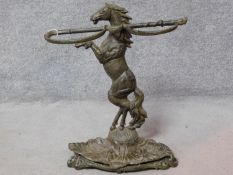 A cast iron rearing horse and whip umbrella/cane stand on a leaf form base. H.66 W.57cm