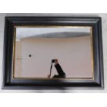 An ebonised and gilt rectangular wall mirror. 84x114cm