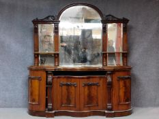 A Victorian style carved flame mahogany sideboard with arched triple section mirrored back.