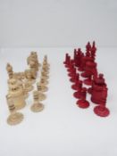 An antique carved bone and red stained bone chess set. The pieces unscrew into sections so can be