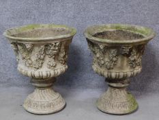 A pair of concrete campana form garden jardinieres with gargoyle and leaf garland decoration. H.58cm