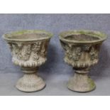 A pair of concrete campana form garden jardinieres with gargoyle and leaf garland decoration. H.58cm