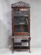 A late 19th century Chinese rosewood display cabinet with scrolling bamboo carved pediment above