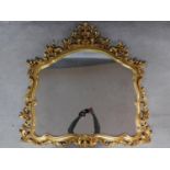 An antique style gilt framed wall mirror with floral surmount and decoration. 116x113cm