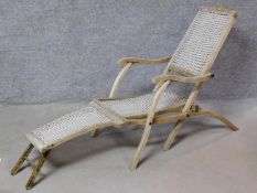 A vintage rustic teak folding steamer chair with footrest. H.86 W.52 D.160cm