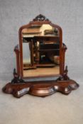 A Victorian mahogany swing framed toilet mirror on shaped platform base fitted with jewellery