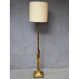 An Art Deco brass standard lamp of geometric outline and square stepped base resting on four block