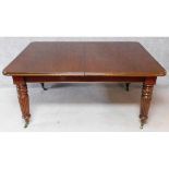 A Victorian style mahogany extending dining table on turned reeded tapering supports with three