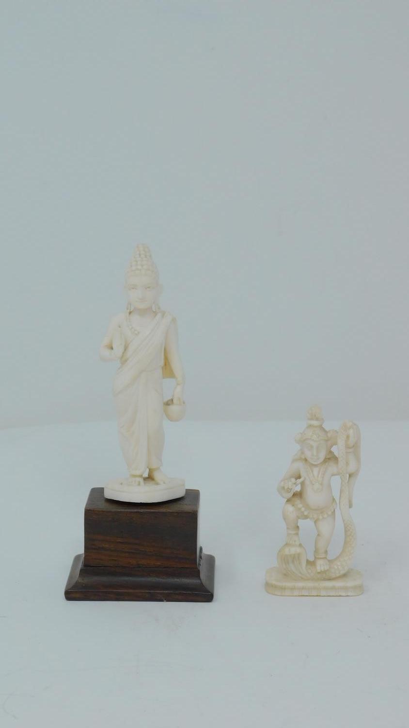 Two antique ivory carved statues, one of the buddha and one of a Hindu deity depicted holding a