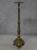 An antique floor standing brass pricket candlestick. H.77cm