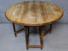 An antique style country oak drop flap dining table on turned stretchered supports. H.76 W.120 D.