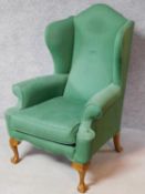 A Georgian style wing back armchair on cabriole supports. H.120cm